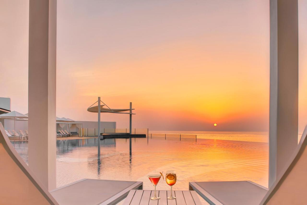 Royal M Al Aqah Beach Resort By Gewan Kültér fotó Sunset at the pool